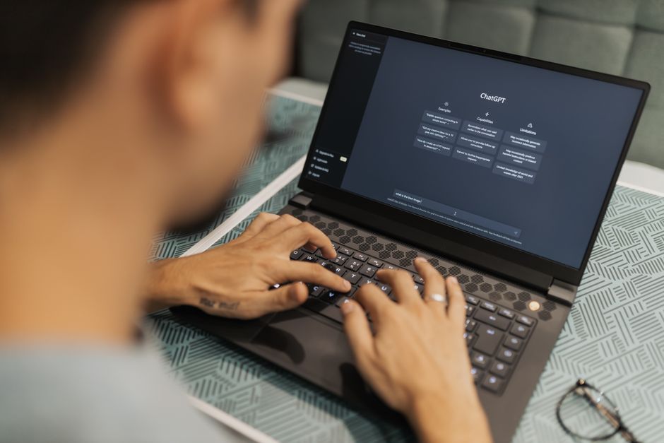 A vacation rental host uses a laptop to write property descriptions with the help of AI tools like ChatGPT.